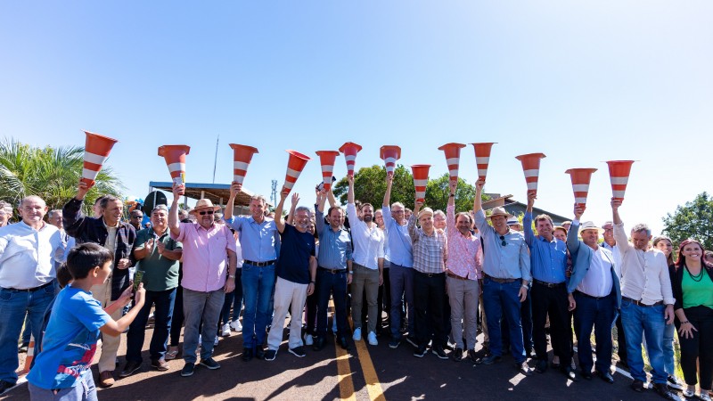Grande grupo de pessoas aparecem lado a lado na pista da rodovia Emília Corrêa Chiapetta, no município de Chiapetta, erguendo cones de trânsito para simbolizar a inauguração da pavimentação de 5,2 quilômetros da via. Entre as pessoas, está o governador Eduardo Leite e secretários de Estado que o acompanharam na visita ao município neste sábado (1º/4/2023).