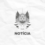 Imagem em tons de cinza, com o bras&atilde;o do Rio Grande do Sul centralizado sobre fundo branco com textura de papel amassado. Abaixo do bras&atilde;o, aparece a palavra &ldquo;NOT&Iacute;CIA&rdquo; em letras mai&uacute;sculas e em negrito.