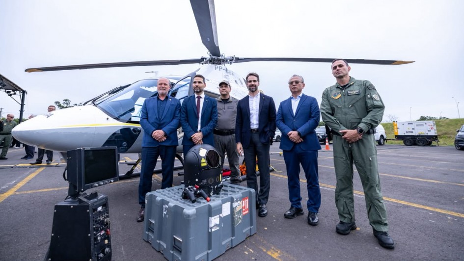 Foto mostra o governador Eduardo Leite em frente ao helic&oacute;ptero com outras autoridades e militares.